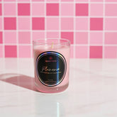 Pink candle with a label on a pink checkered background