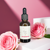 Bottle of Rose Rose skincare product with pink roses on a pink background
