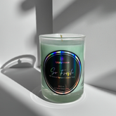 Green so fresh Candle in a glass jar with a label on a white surface
