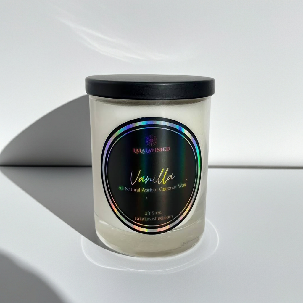 Vanilla-scented candle with a black lid on a white surface